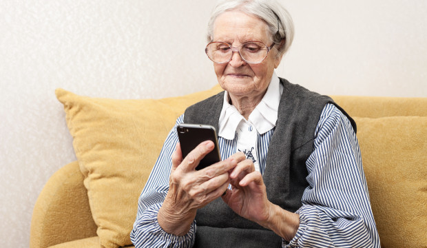 Oudere dame aan het appen met mobiele telefoon